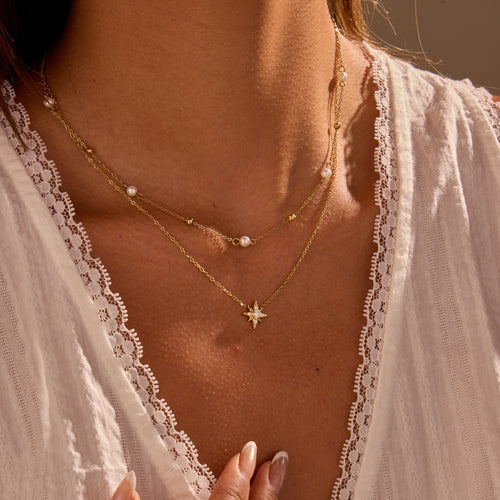 A double-layered six-pointed star necklace adorned with diamonds and pearls